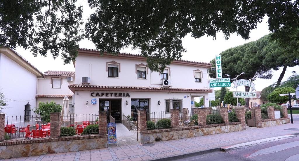 un bâtiment blanc avec des chaises rouges devant lui dans l'établissement Hotel Andalucia, à Ronda