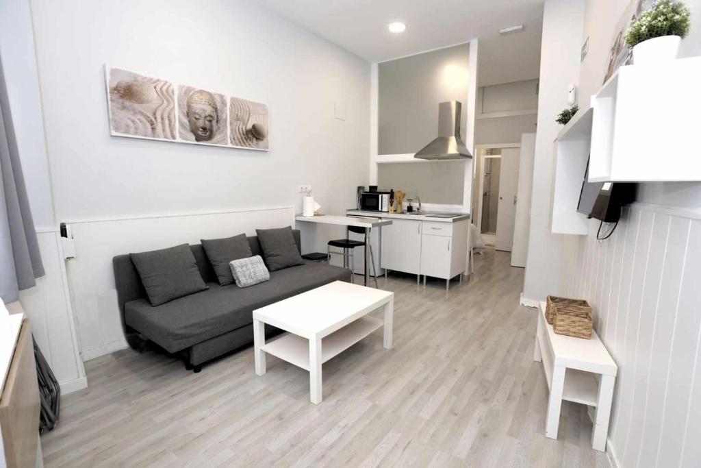 ein Wohnzimmer mit einem Sofa und einem Tisch in der Unterkunft La casita de Valvanera in Madrid