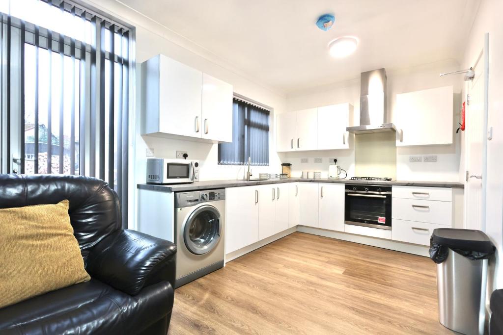 a kitchen with a black leather couch in a room at Studio 22 Lower Road Beeston in Nottingham