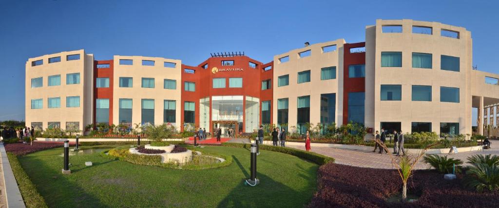 a group of buildings with a park in front of them at Bravura Gold Resort in Meerut