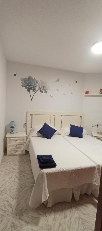 een slaapkamer met een groot wit bed met blauwe kussens bij La Cala de Vida in La Cala de Mijas
