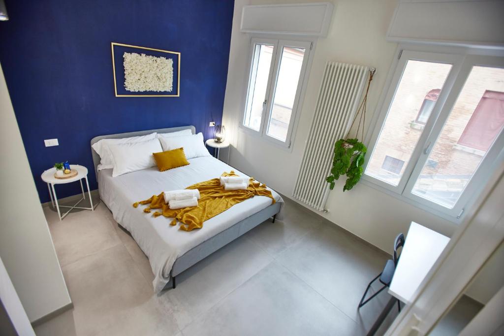 um quarto com uma cama com uma parede azul em LikeHome Apartment -3Rooms - 10persone -Ferrara em Ferrara