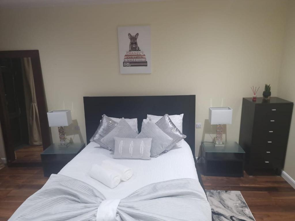 a bedroom with a white bed with two night stands at Lux 2 Bed Flat in Canary Wharf in London