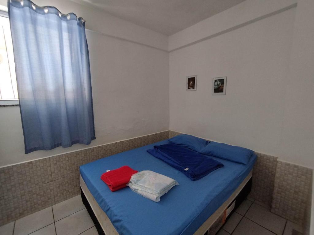 ein Zimmer mit einem blauen Bett mit zwei Handtüchern darauf in der Unterkunft Seu Apto na Praia da Costa 2 Local Excelente Ar Cond Frigobar Microondas Tv Todo seu Centro in Vila Velha