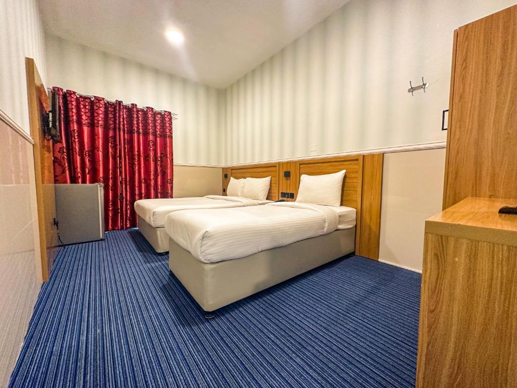 a hotel room with two beds and red curtains at TAMARIND HOTEL in Dubai