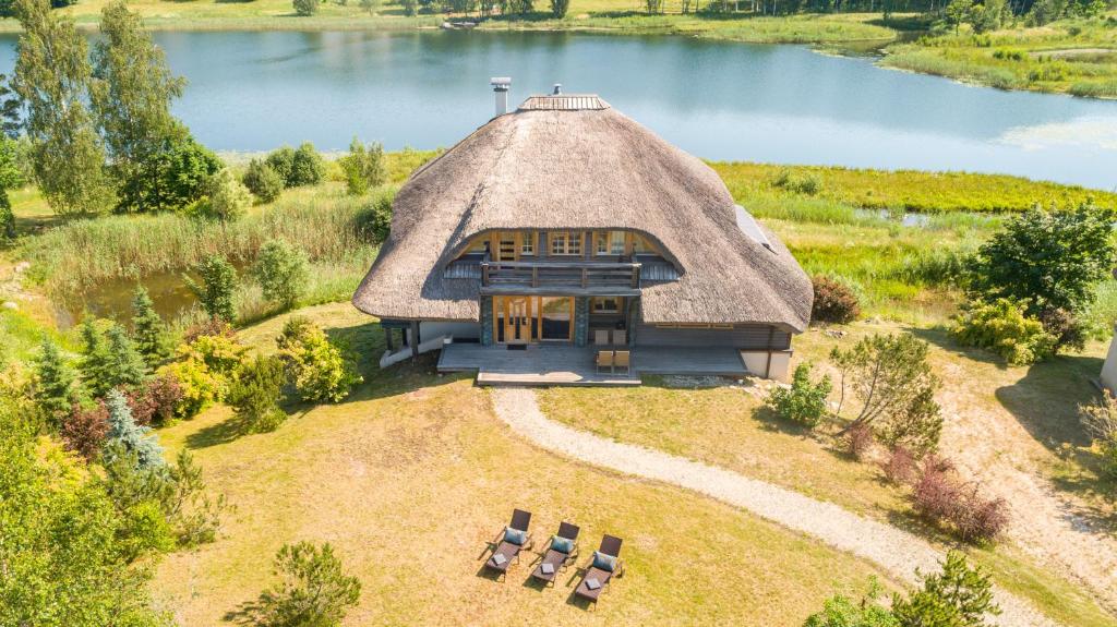Amatciems的住宿－Koka Maja，茅草屋顶房屋的空中景观