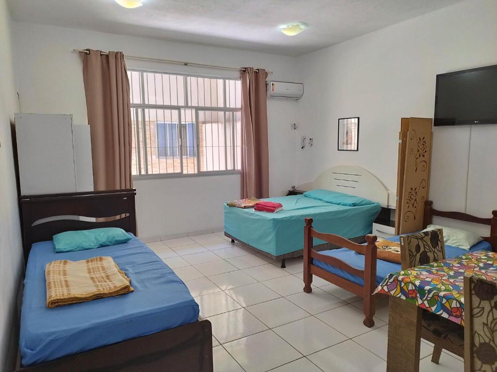 une chambre avec deux lits et une télévision dans l'établissement Seu Apto Praia da Costa 3 Não divide Completo Ar Cond Fogão Geladeira Internet Local Excelente Centro Sem escadas, à Vila Velha