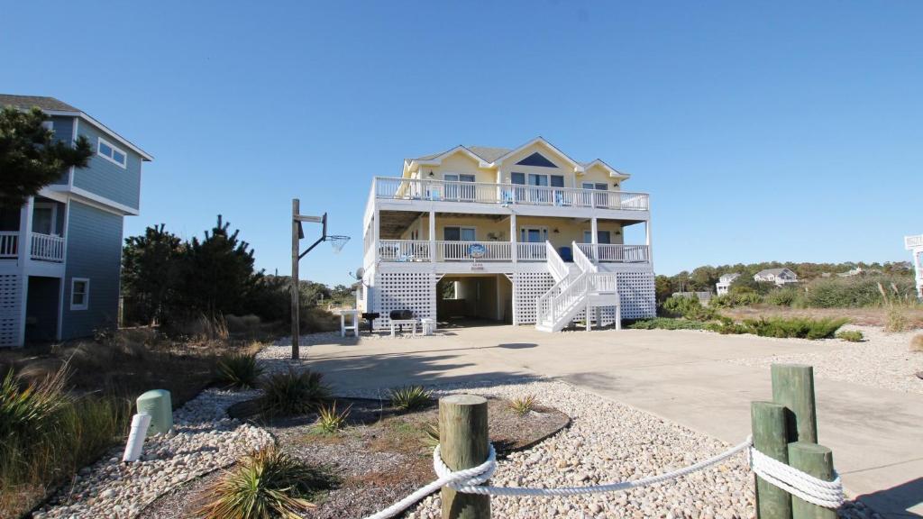a large house on the beach with a fence at Oceanside, 7 BRs, Priv Pool, H Tub, Community Amenities, VOH3, Safe Harbor in Corolla