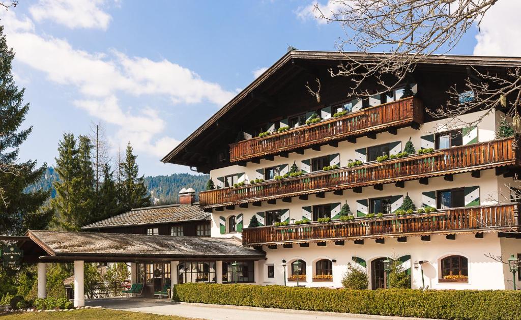 een groot wit gebouw met houten balkons bij House of Hütter - Wachtelhof Hotel & Spa in Maria Alm am Steinernen Meer