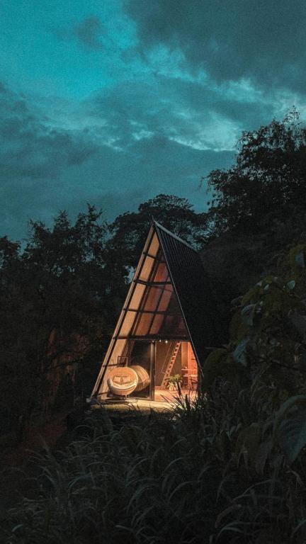 une petite maison au milieu d'une forêt la nuit dans l'établissement Cabaña 25km de Medellín, Benevento Glamping, à Girardota