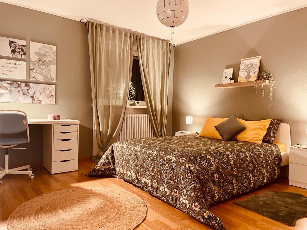 a bedroom with a bed and a desk and a window at Guest House in Luxembourg