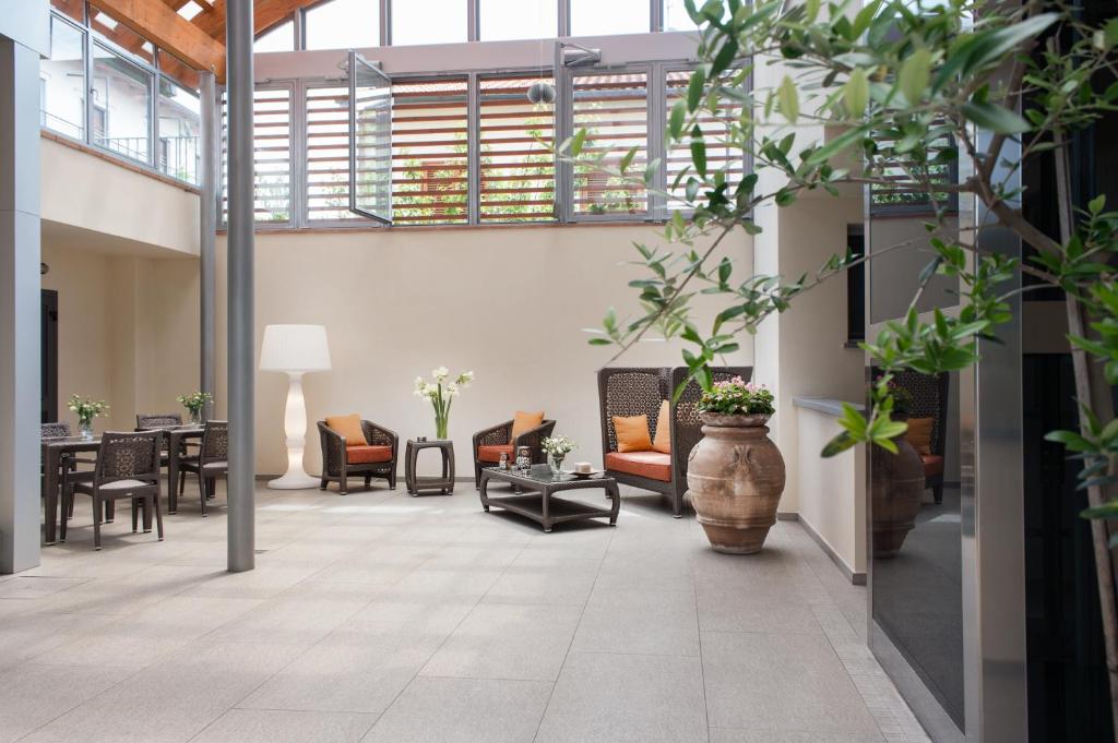 a lobby with chairs and tables and a large vase at Hotel La Villetta in Calenzano