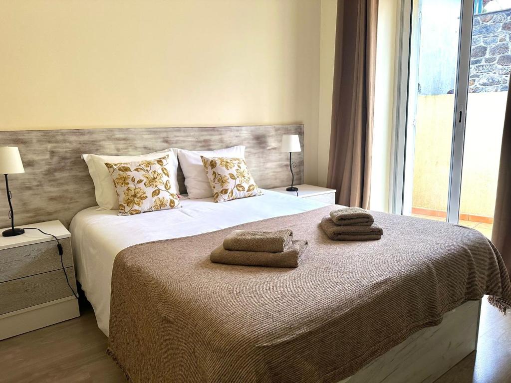 sypialnia z łóżkiem z ręcznikami w obiekcie Casa das Ginjas w mieście São Vicente
