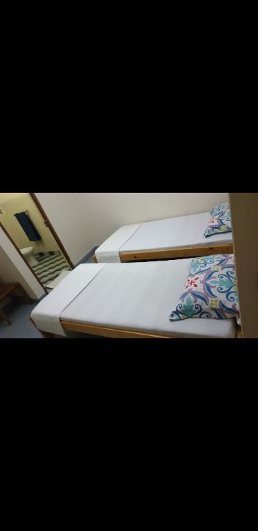 - deux lits assis l'un à côté de l'autre dans une pièce dans l'établissement Residencial Natur, à Tarrafal