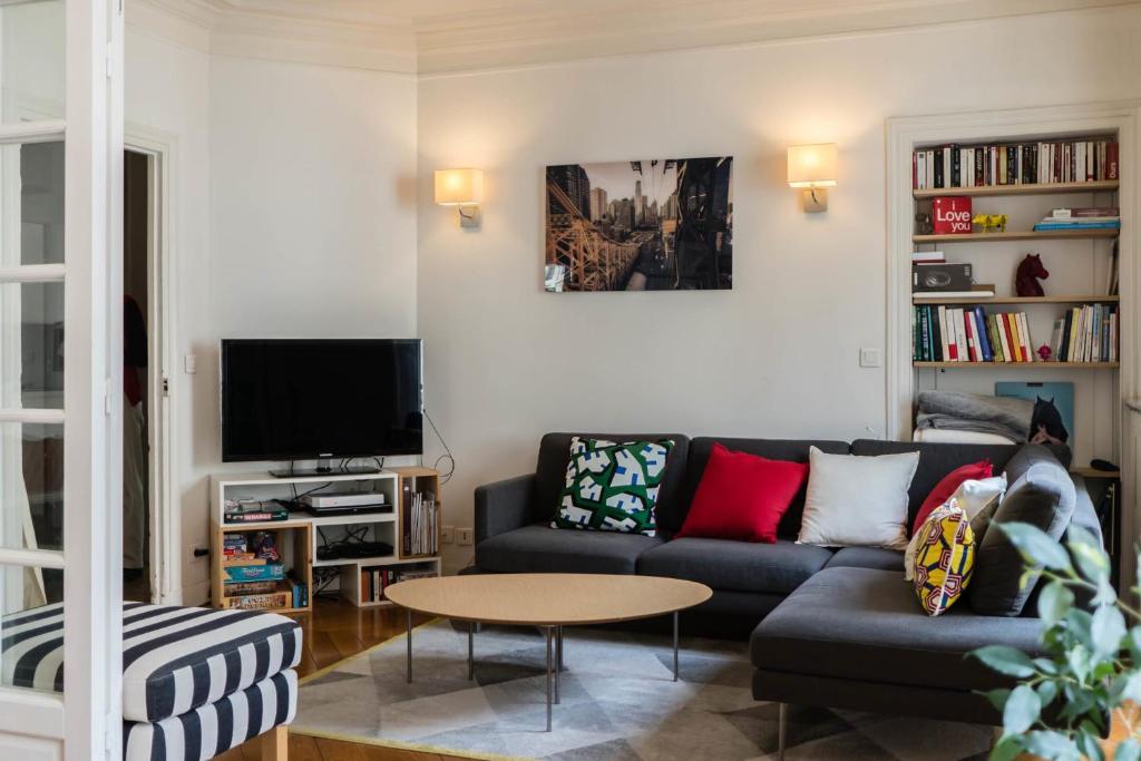 a living room with a couch and a tv at Beautiful &amp; Bright Apartment Near Pigalle in Paris