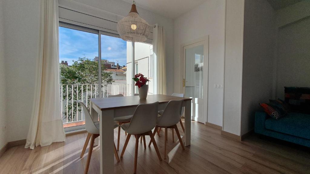 a dining room with a table and chairs and a window at Apartamento nuevo en Terrassa Centro in Terrassa