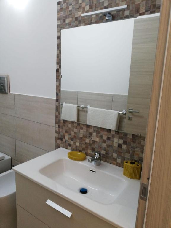 a bathroom with a white sink and a mirror at Blu Mare Lampedusa Bed And Breakfast in Lampedusa