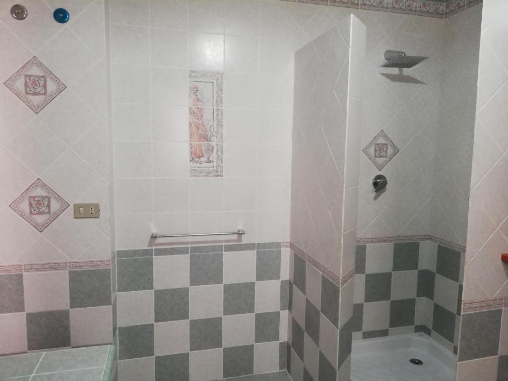 a bathroom with a shower with a checkered floor at Blu Mare Lampedusa Bed And Breakfast in Lampedusa