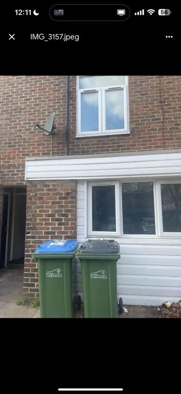 two trash cans sitting in front of a house at ST Anthony Ensuite Room in Woolwich