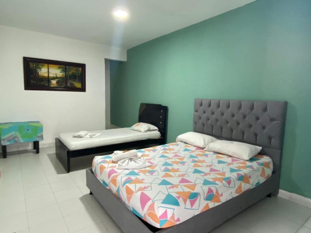 um quarto com uma cama e uma cama e uma roupa de cama. em HOTEL SANTA MONICA em Barranquilla
