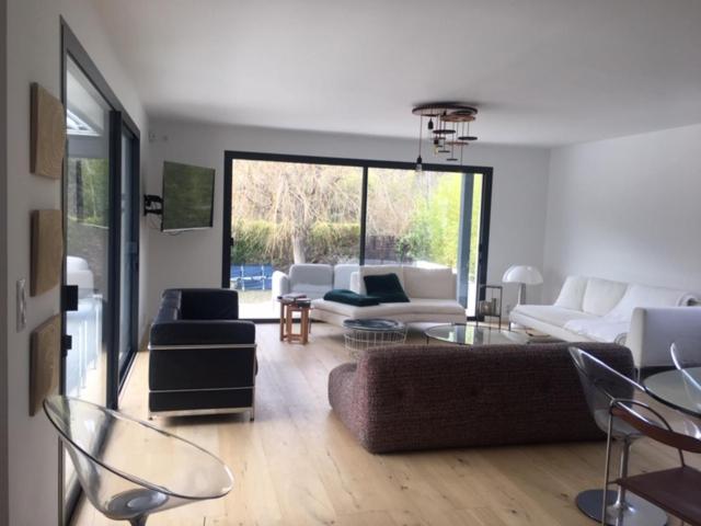 ein Wohnzimmer mit einer Couch und einem Tisch und Stühlen in der Unterkunft Maison proche centre de Montpellier au calme in Saint-Clément-de-Rivière