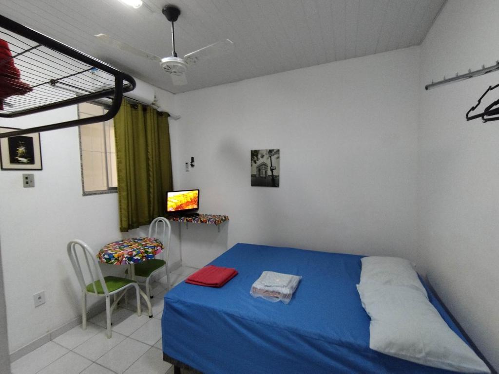 - une chambre avec un lit bleu et une chaise dans l'établissement Seu Apto na Praia da Costa 6 Excelente Local Ar Cond TV Microondas Internet Rápida Todo seu Centro, à Vila Velha