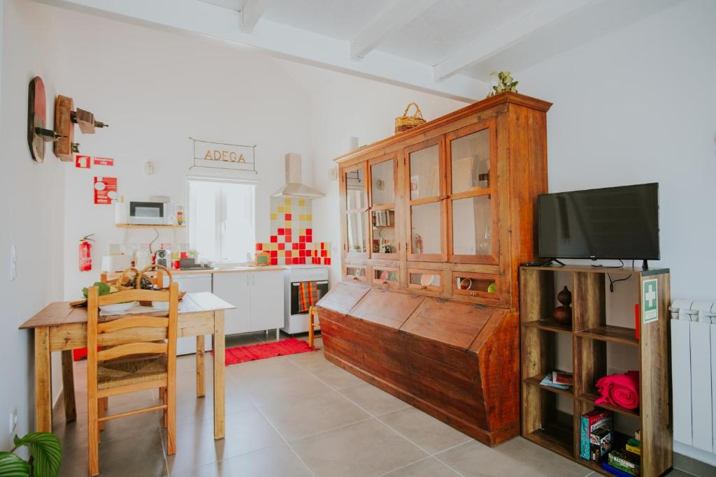 una cucina con un tavolo e una tv in una stanza di Casa do Meio a Cela