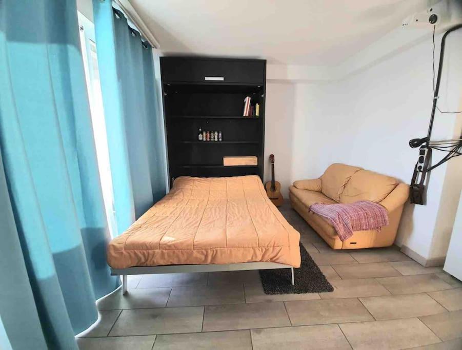 ein kleines Schlafzimmer mit einem Bett und einem Sofa in der Unterkunft Beach Penthouse in Almería