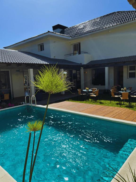 a swimming pool in front of a house at HAS Hotel Boutique in Bella Unión