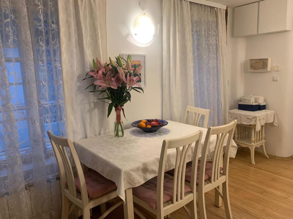 a dining room with a table with a vase of flowers at Apartment St. Marko in Zagreb