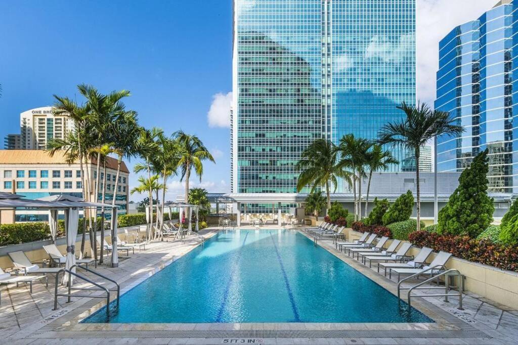 a pool with chairs and palm trees and buildings at Brickell Apt Free Parking 4 People Pool Ocean View in Miami