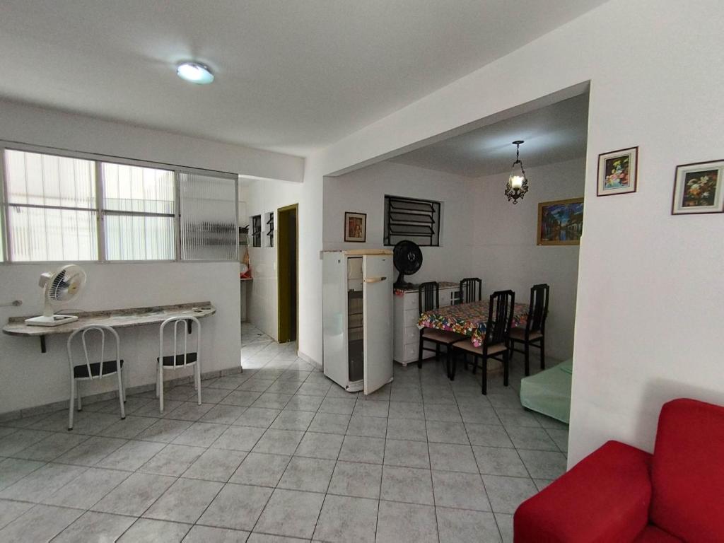 Il comprend un salon avec un canapé rouge et une cuisine. dans l'établissement Seu Apto na Praia da Costa 7 Completo 2Q 2B 2S Ar Cond Geladeira Fogao TV Maq Lavar Centro Sem escadas, à Vila Velha