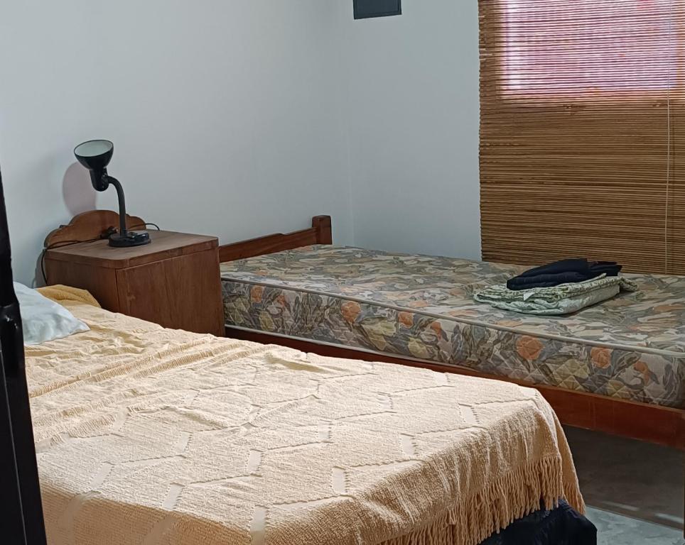 a bedroom with two beds and a lamp on a table at El cardenal in Gualeguaychú