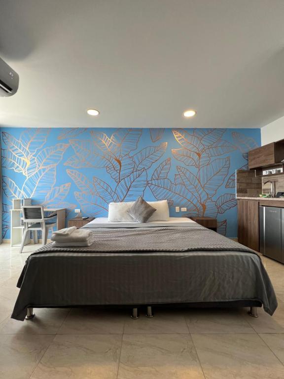 1 dormitorio con 1 cama grande y pared azul en Bahia 79 Apartasuites Cerca al Centro, en Cartagena de Indias