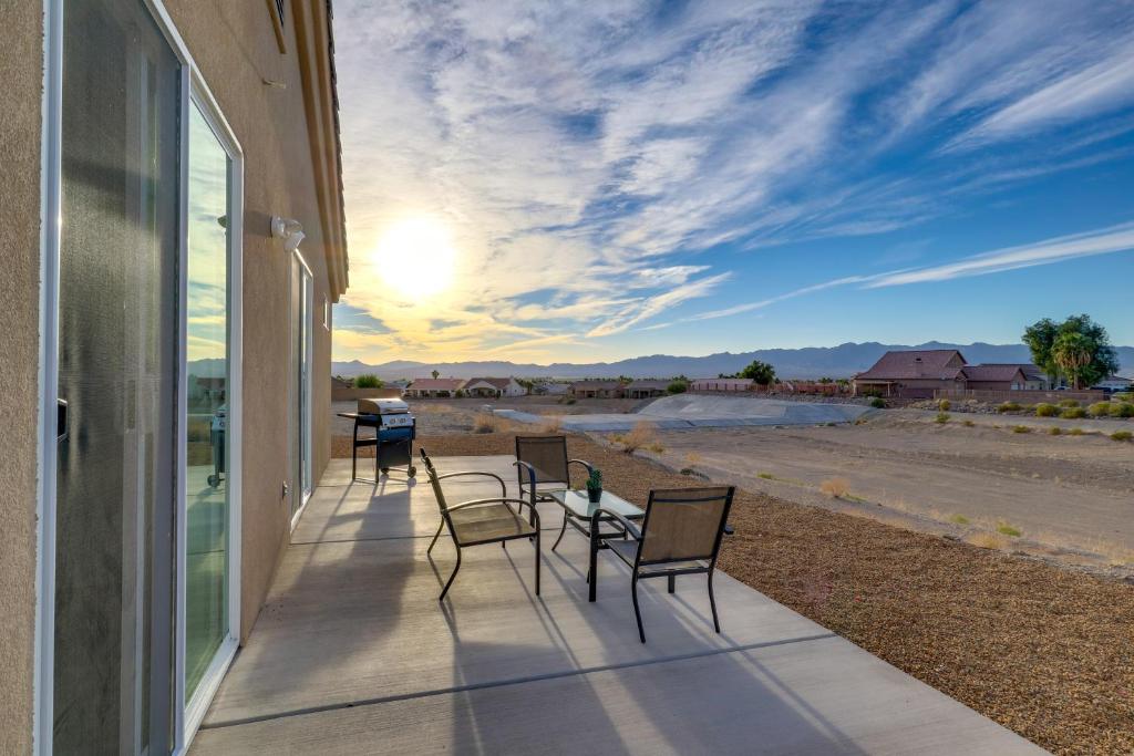 a porch with chairs and a table with a view of the desert at Modern Fort Mohave Home with Patio and Grill! in Fort Mohave