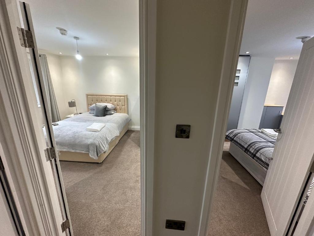 a bedroom with a bed and a door leading into a room at 5 bedroom house in Orpington in Orpington