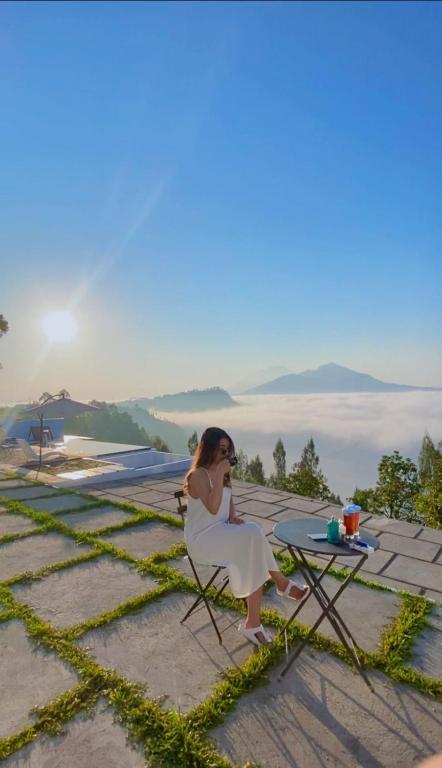 a woman sitting in a chair next to a table at Highland Bali in Baturaja