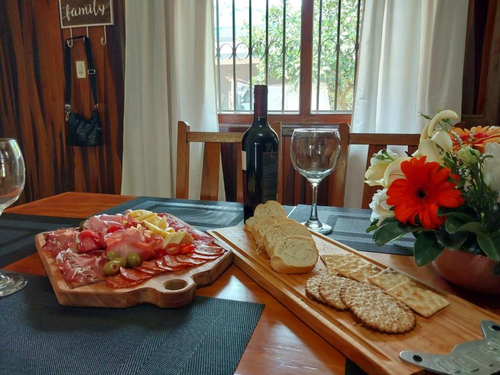 einen Tisch mit einem Teller Essen und einer Flasche Wein in der Unterkunft La esquina in Dos de Mayo