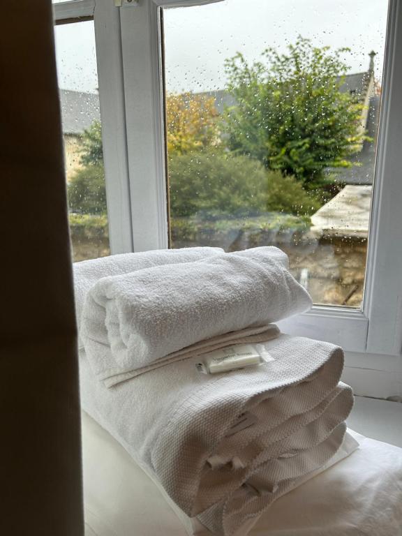 a pile of towels sitting next to a window at La Belle Vicoise in Vic-sur-Aisne