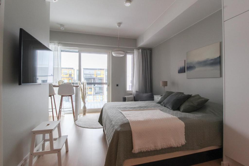 a bedroom with a bed and a large window at City Apartment Kallaveden Marina in Kuopio