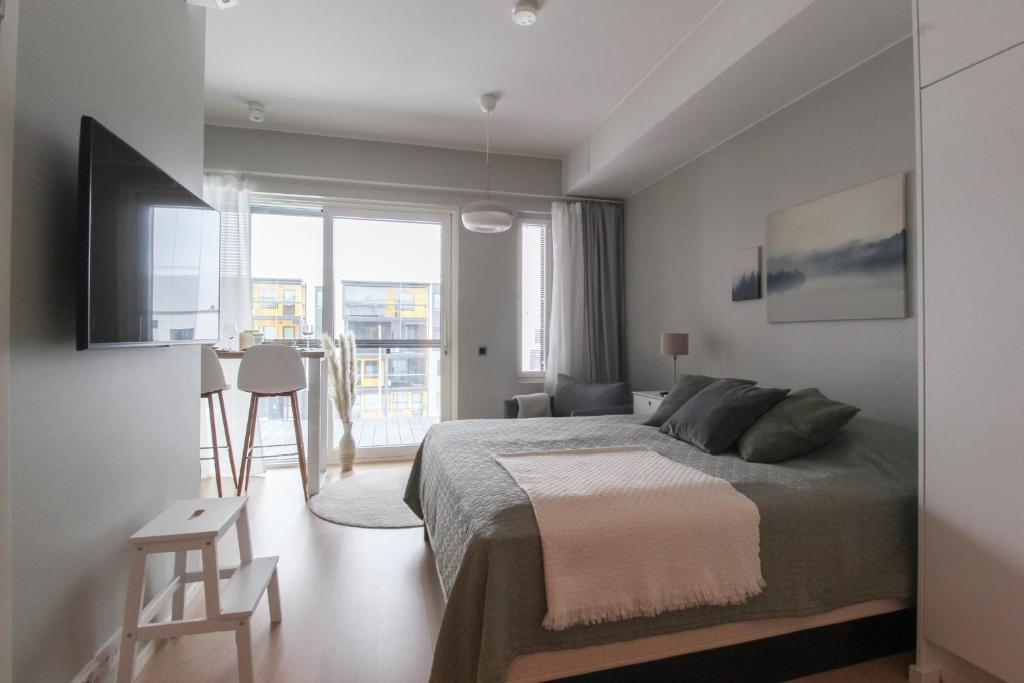 a bedroom with a bed and a large window at Pramea Apartments Marina in Kuopio