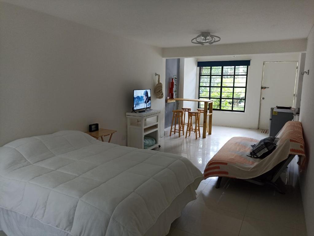 - une chambre avec un lit blanc, une table et des chaises dans l'établissement Studio - MOLAS by Walter de la Renta, à Cancún