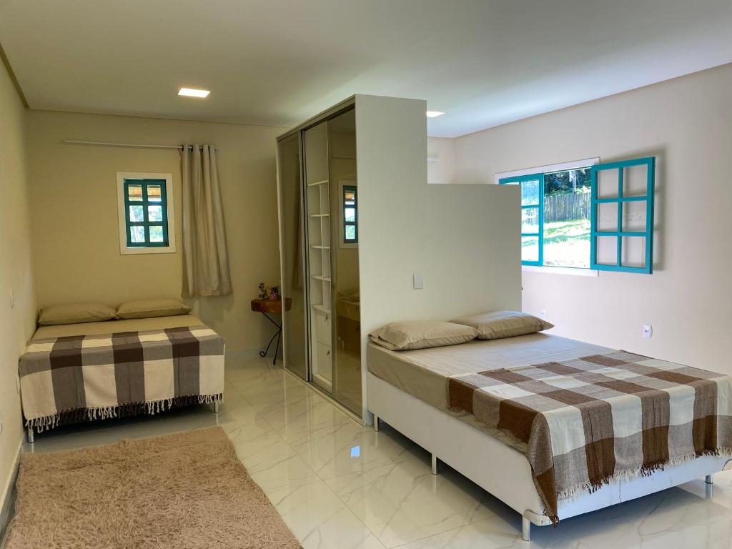 a bedroom with two beds and a window at Sítio Casa Vida Nova in Itacaré