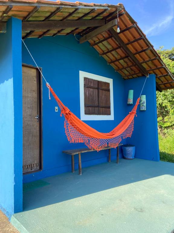 a blue house with an orange hammock hanging from it at Pousada Nikimba in São Roque de Minas