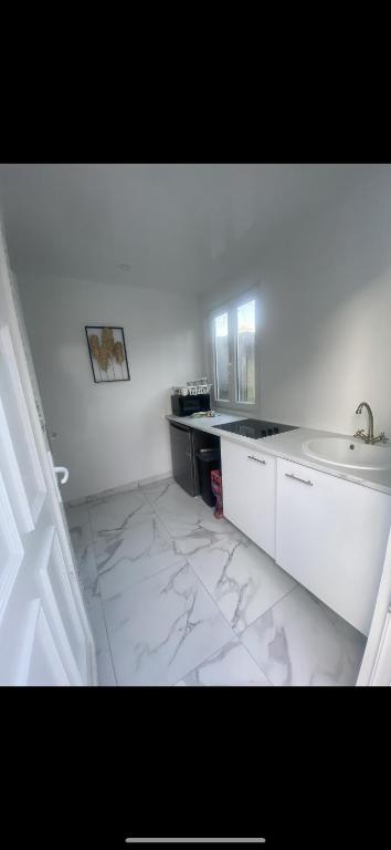 Appartement beau في درانسي: حمام أبيض مع حوض ومكتب