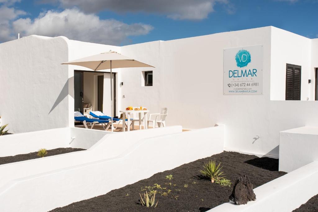 ein weißes Haus mit einem Tisch und Stühlen in der Unterkunft Delmar Natur - Sama in Charco del Palo