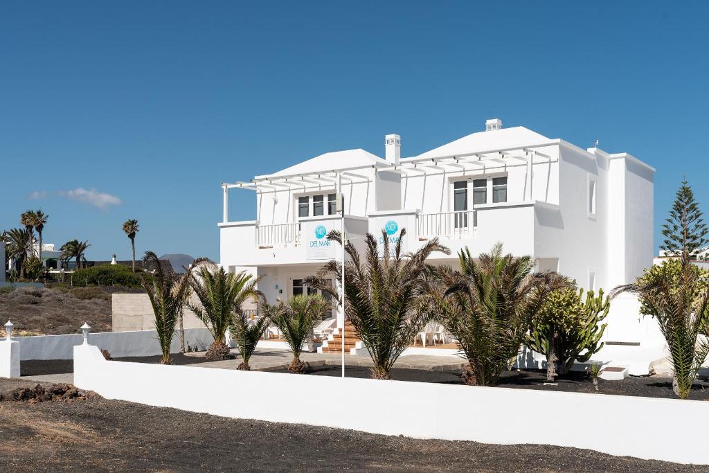 una casa blanca con palmeras delante en Delmar Natur - Gallo, en Charco del Palo