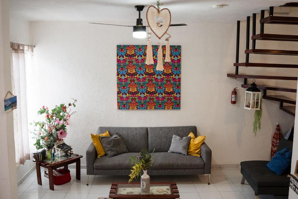 uma sala de estar com um sofá e uma pintura na parede em Casa Aurora em Cancún