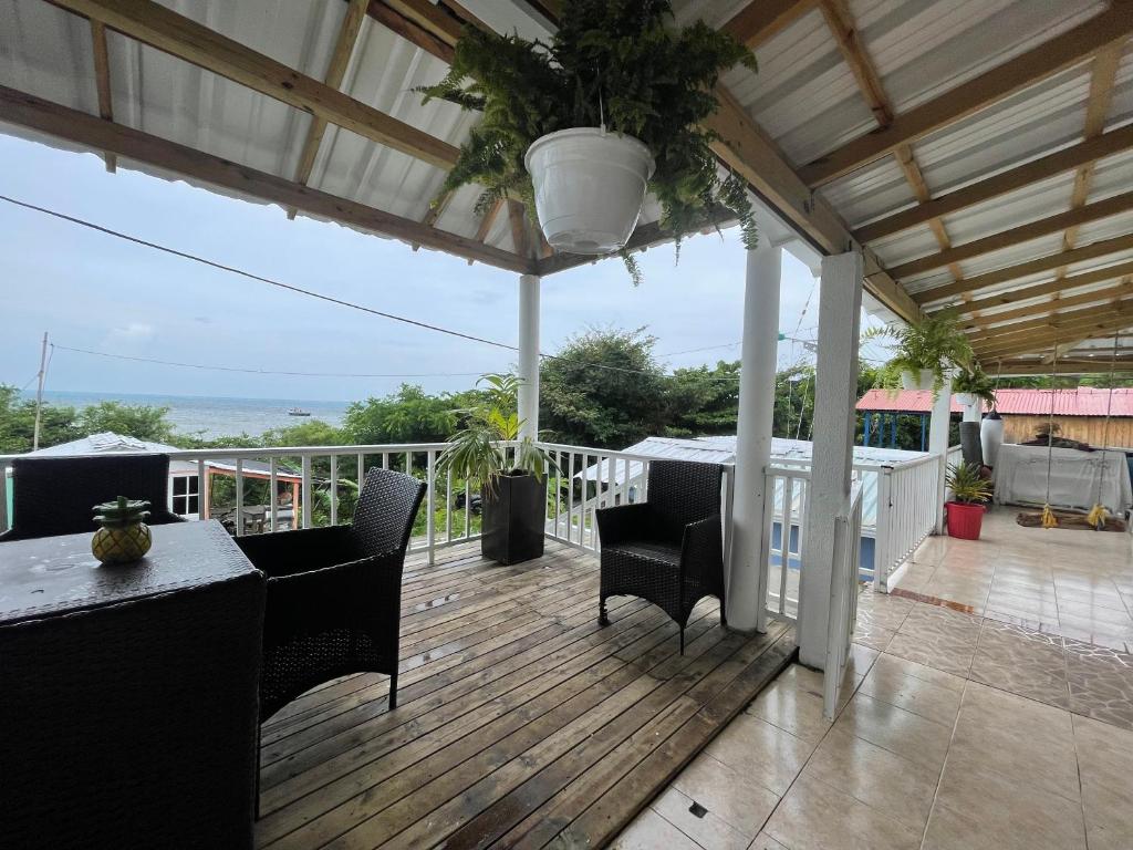 a patio with a table and chairs on a deck at posada sunrise view vacation home in Providencia