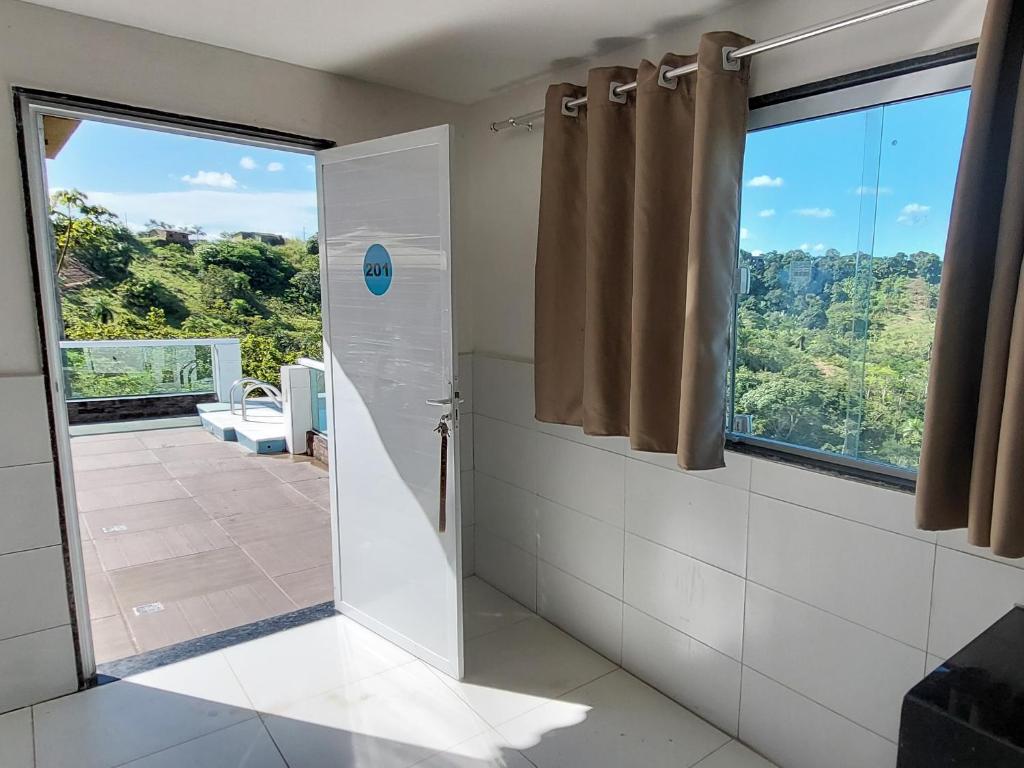 baño con ducha y ventana en Apartamentos Mobiliados, en Aldeia